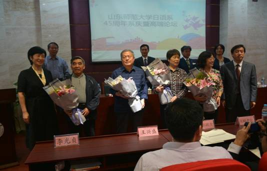 (在校生向老教师献花)