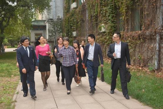 (校友们簇拥着老师走在校园中)